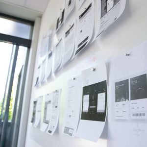 A man examining a wall of paper, deep in thought.