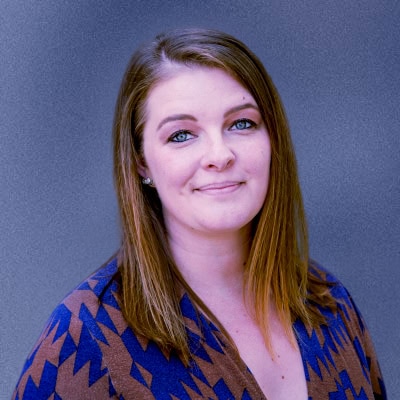 A woman with brown hair and blue eyes, radiating elegance and charm.